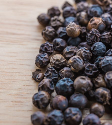 Black pepper on wood background