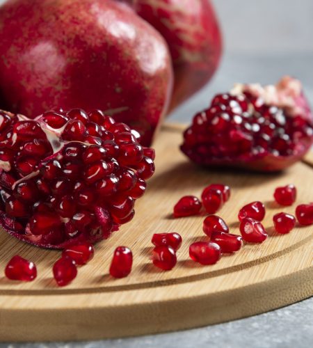 Sliced ripe pomegranate on a wooden board. High quality photo